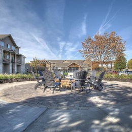 a courtyard with chairs and a fire pit